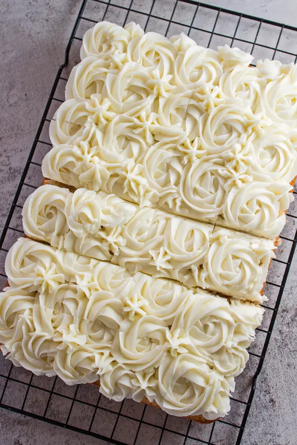 tall overhead image of frosted vanilla tray bake sheet cake.