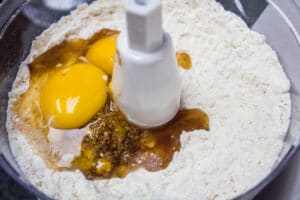 yemas de huevo huevo y extracto de vainilla agregados a la mezcla de mantequilla y harina.