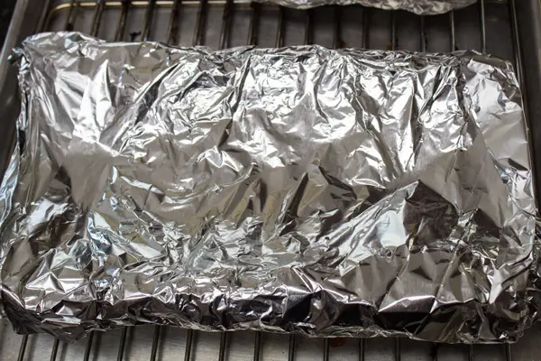 smoked beef back ribs wrapped securely in aluminum foil.