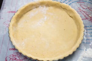 trimmed pastry dough in tart pan for bottom crust.