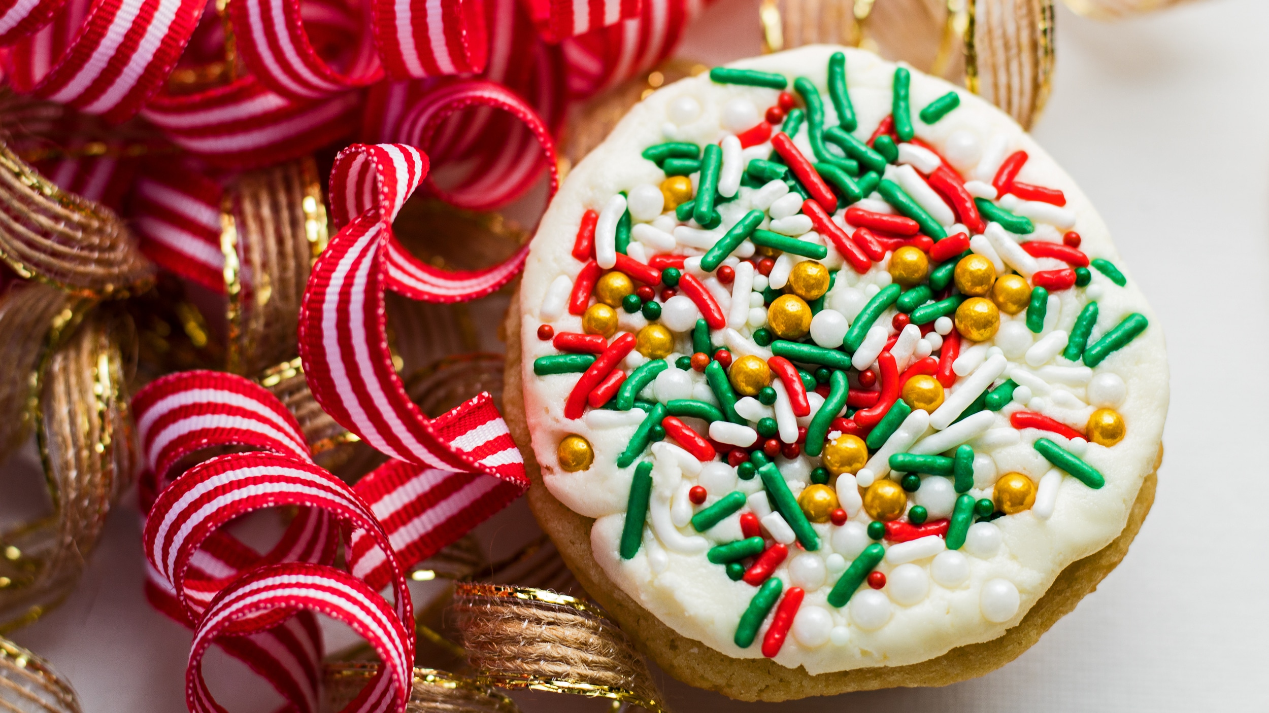 रिबन में क्रिसमस कुकीज़ की चौड़ी ओवरहेड छवि।