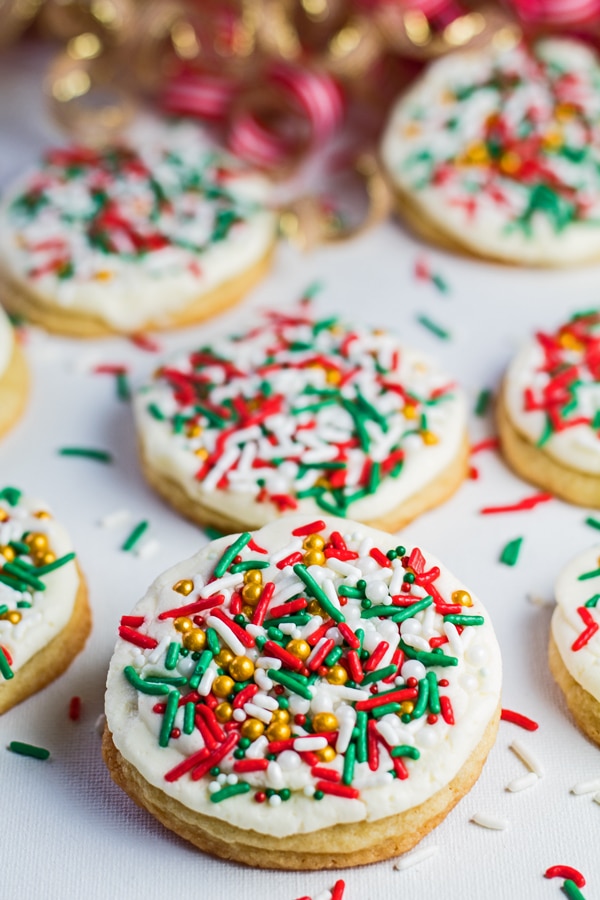 vertical angled overhead image of Christmas cookies with frosting and sprinkles.