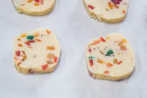 sliced fruitcake shortbread cookies on baking sheet.