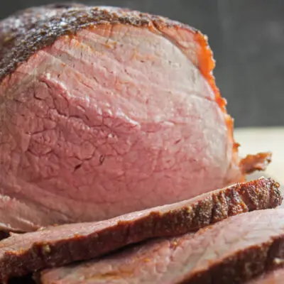 wide image of the perfect Smoked Beef Roast sliced and ready to serve.