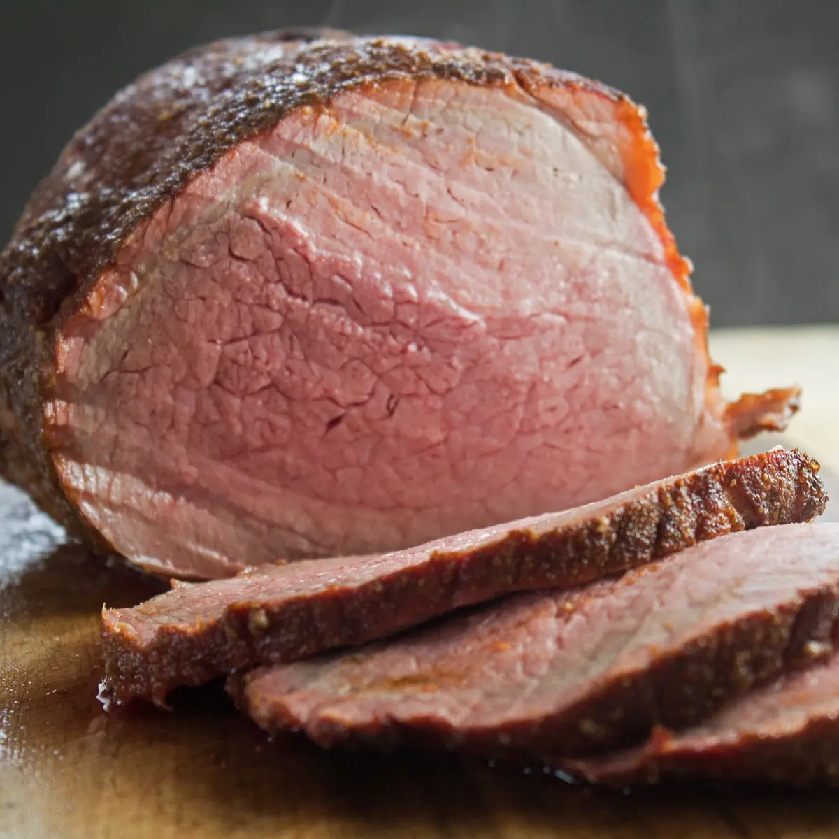 Large square image of the perfect Smoked Beef Roast sliced and ready to serve.