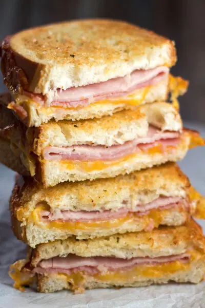 tall closeup image of the stacked air fryer grilled ham and cheese.