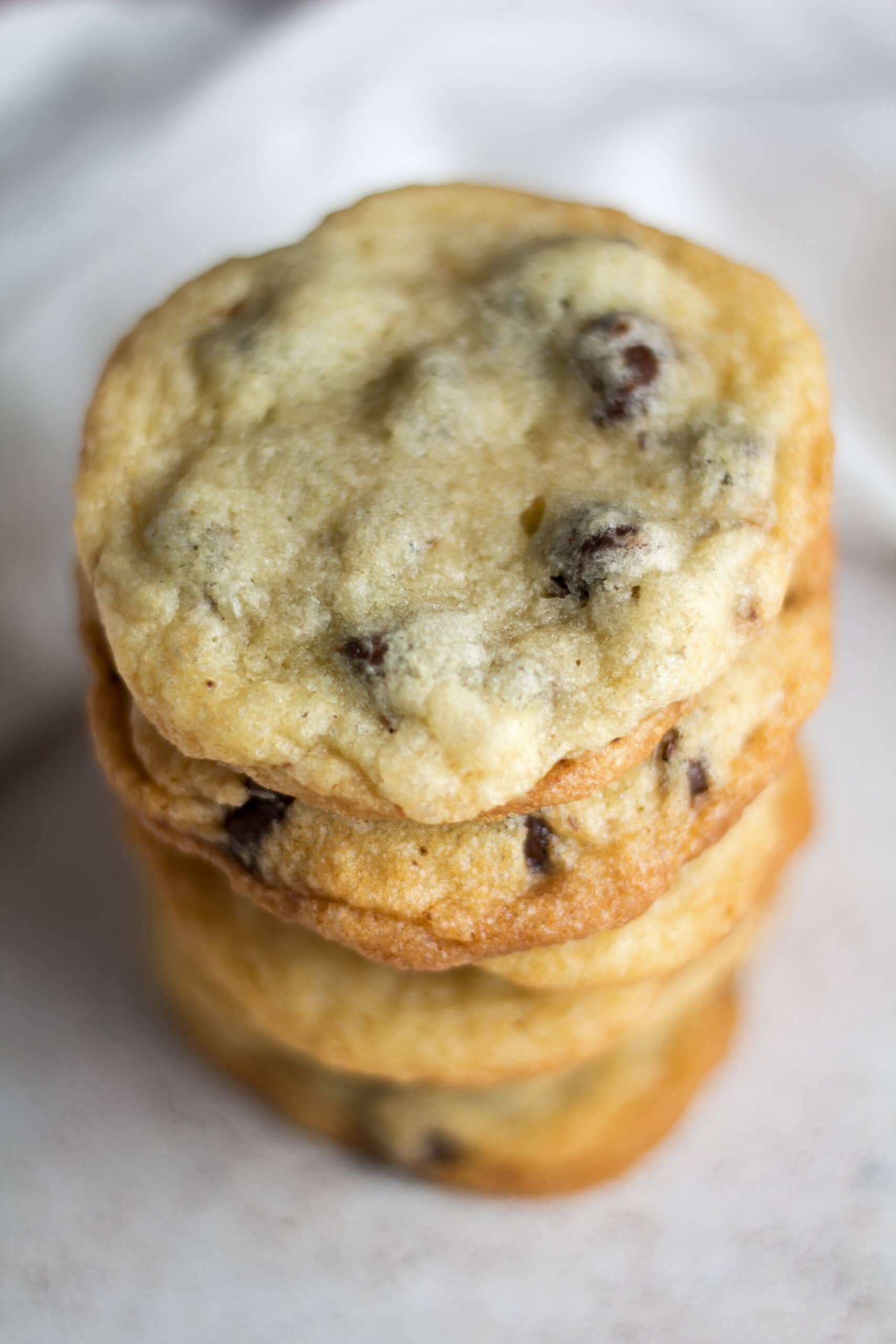 tall image of stacked chocolate chip cookies without brown sugar.