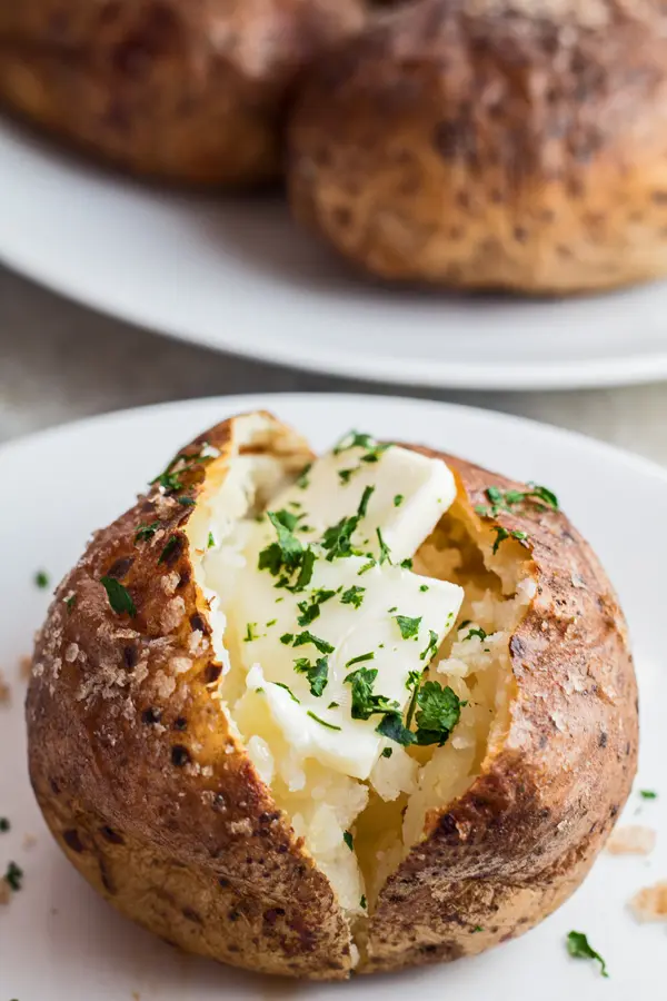 Tall image of tasty smoked baked potato with butter.