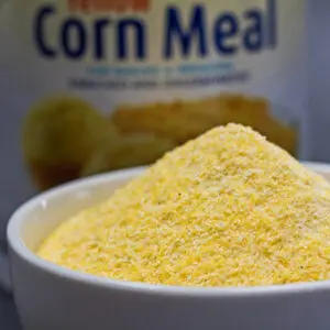 Large square image of yellow cornmeal in white bowl.