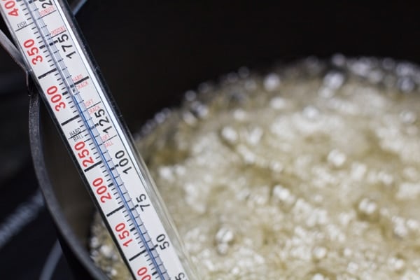 candy thermometer submerged into the boiling syrup.