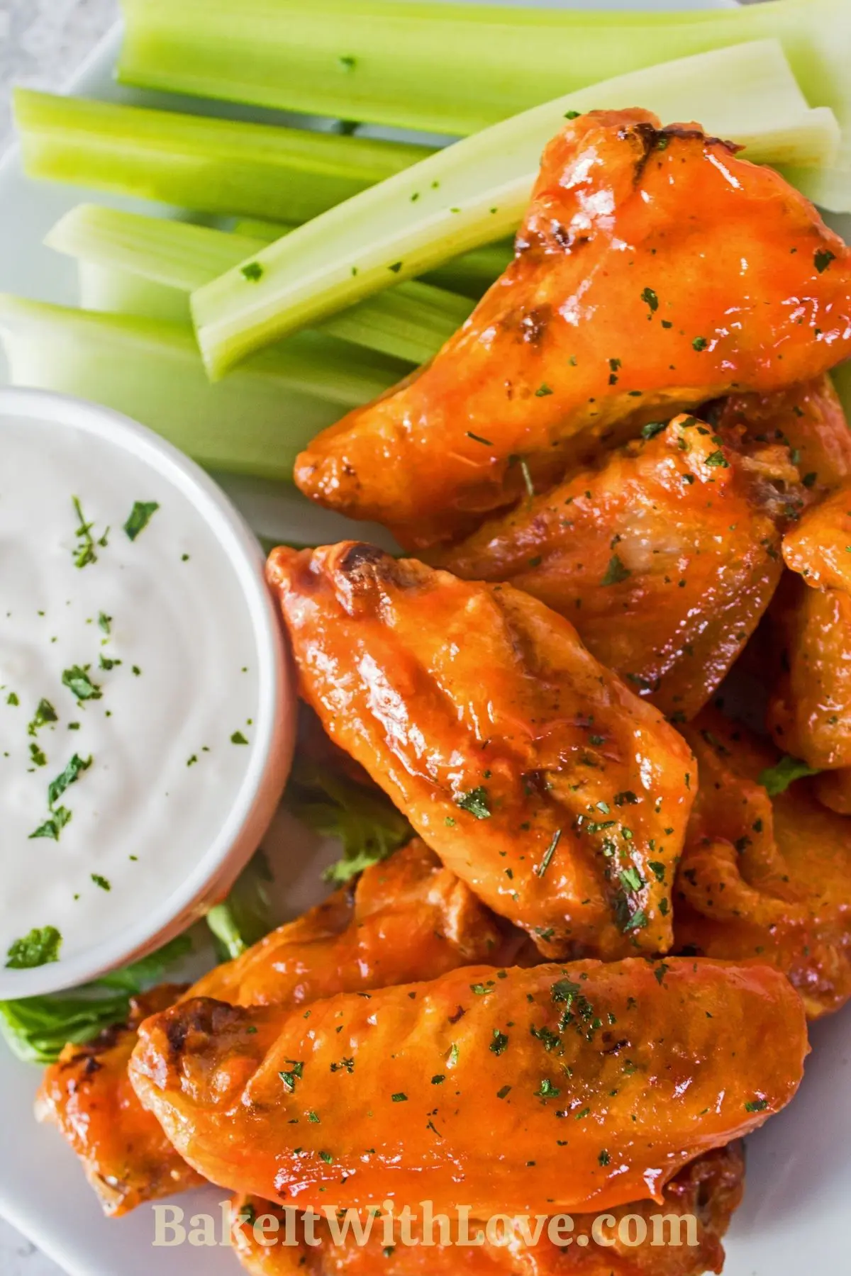 Air fryer frozen chicken wings served with celery sticks and ranch dressing.