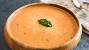 Wide image of super creamy roasted tomato basil soup.