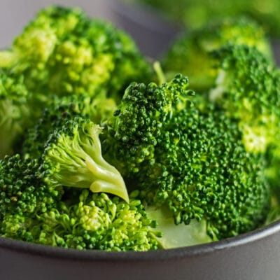 Closeup on microwave steamed broccoli in black bowl.