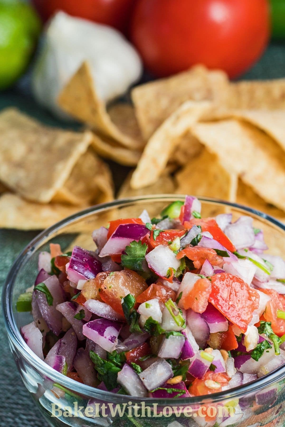 Pico de gallo served in clear bowl with chips and fresh ingredients.