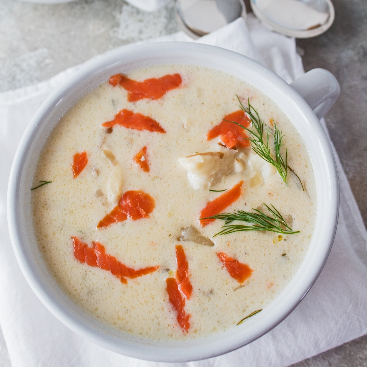 مربعة الشكل من حساء المأكولات البحرية مع سمك السلمون المدخن في وعاء أبيض.