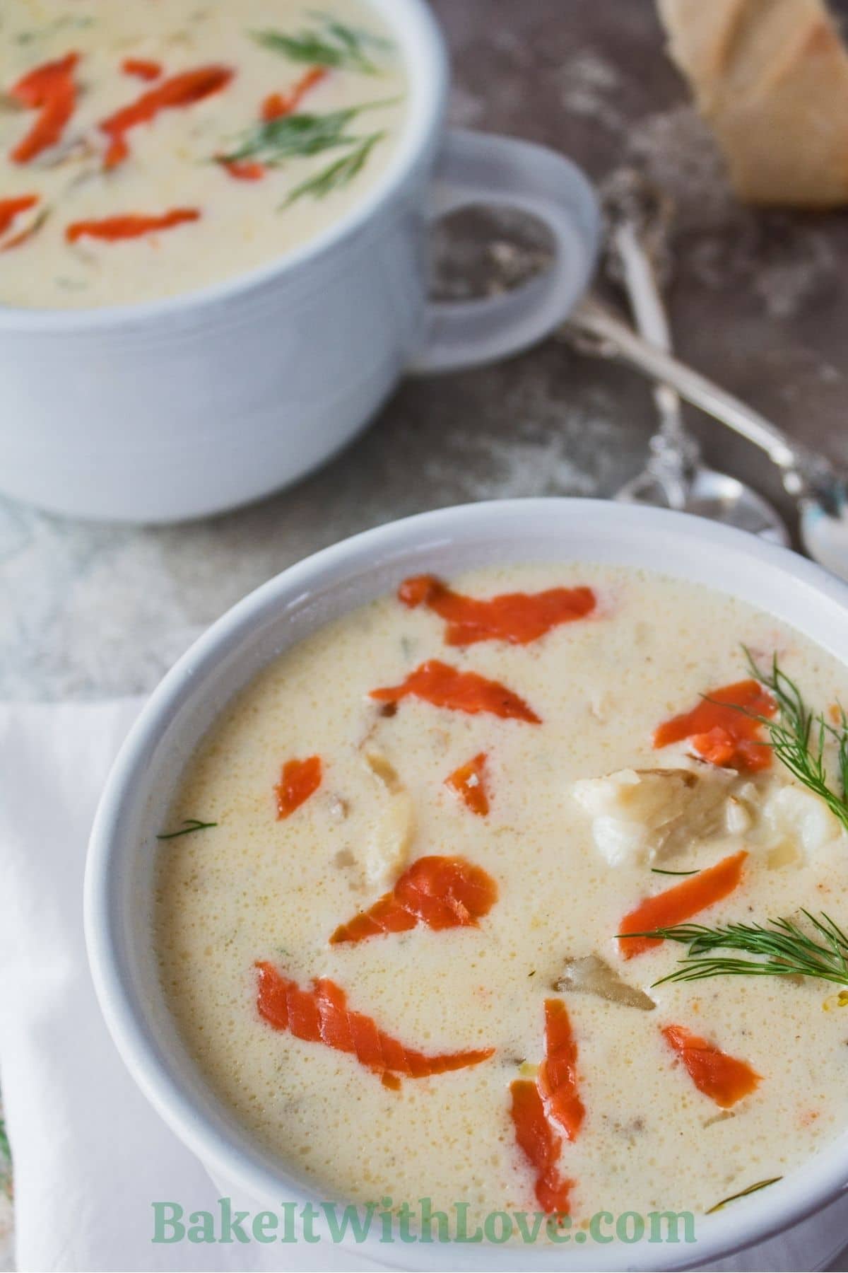 Seafood chowder with smoked salmon served in white bowls.