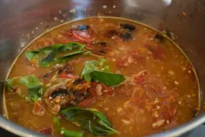 Chicken broth added to the sauteed base and tomatoes.