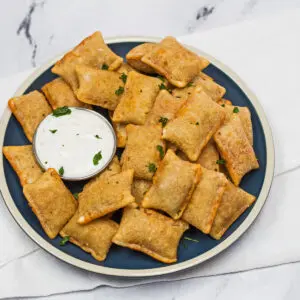 Frozen pizza rolls cooked in the air fryer and served with dipping sauce.