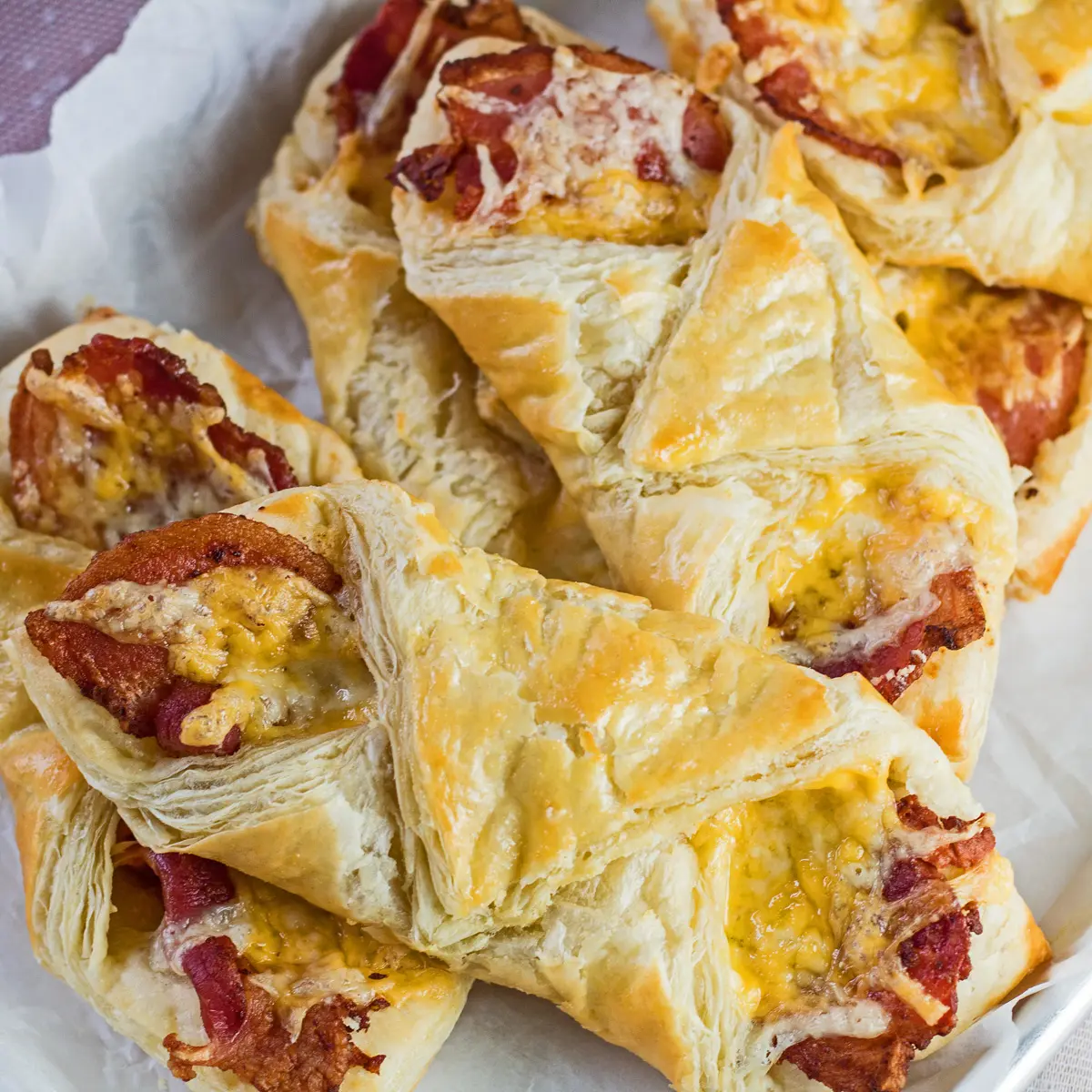 Golden cheese and bacon turnovers on serving tray.