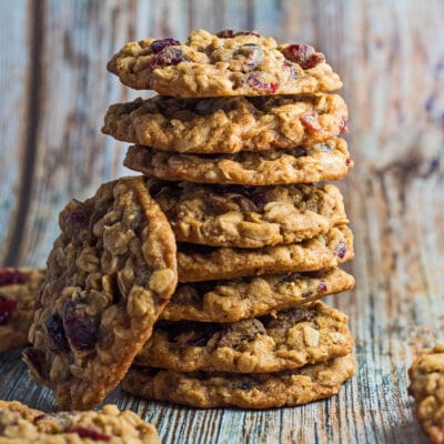 Oatmeal craisin cookies stacked with wooden grain background.
