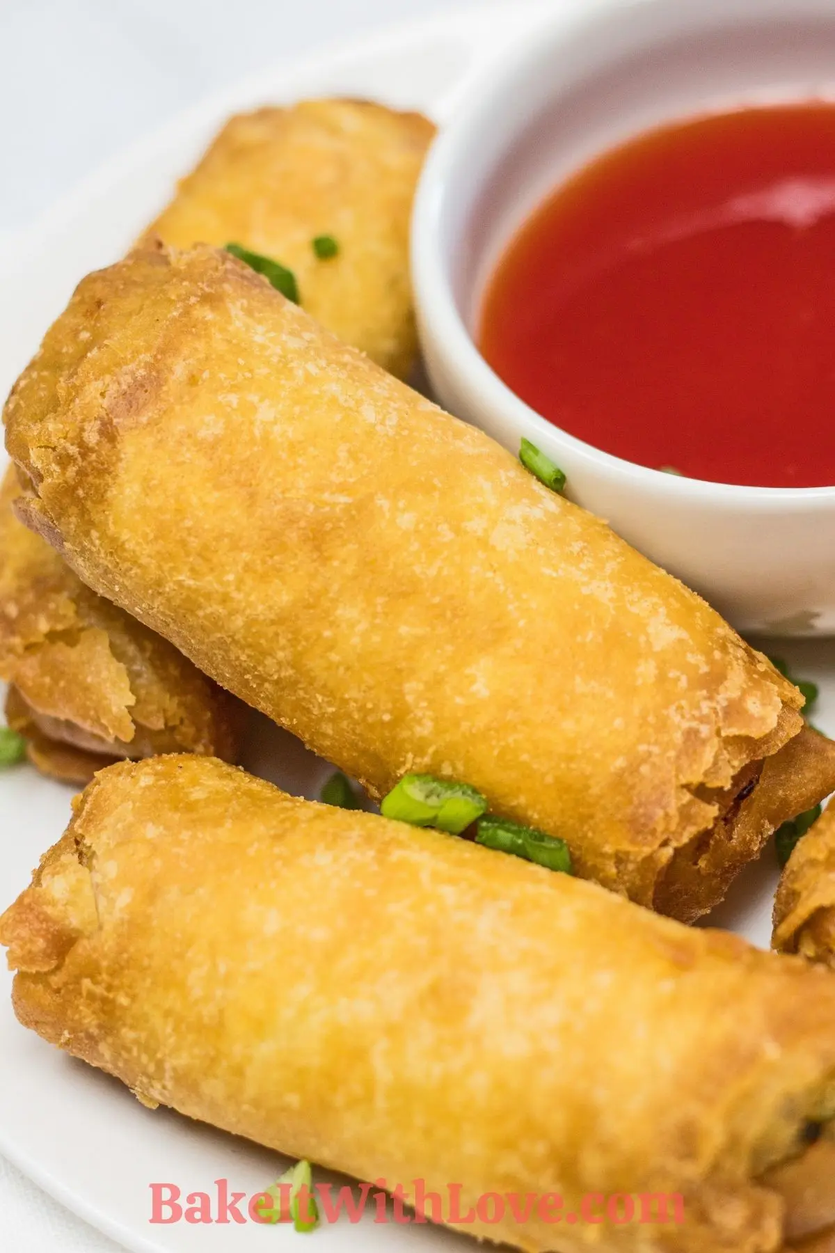 Frozen egg rolls after cooking in the air fryer served with sweet and sour sauce.