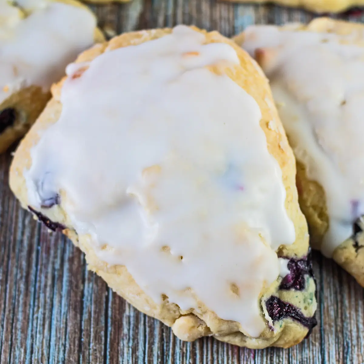 Blueberry white chocolate scone on a wooden background.