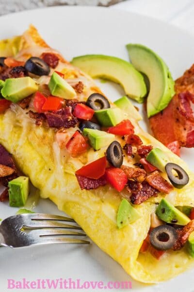 California omelette with bacon and avocado on a white plate.