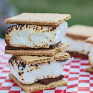 2 s'mores stacked on a picnic table.