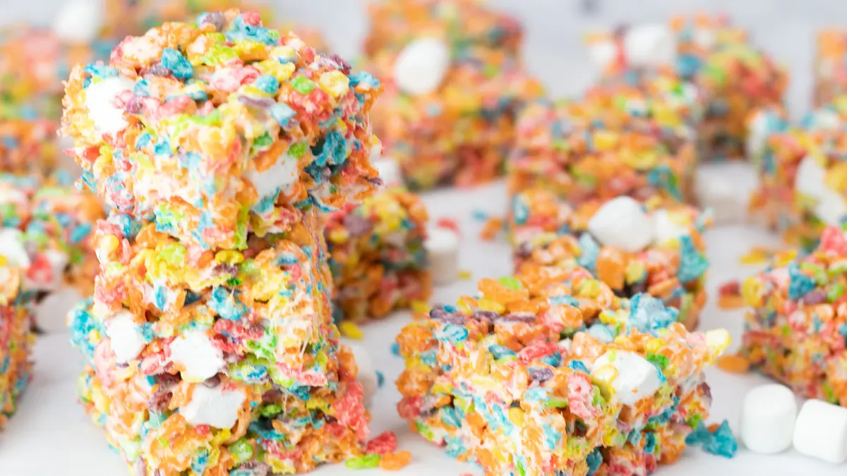 Wide image of fruity pebbles treats on a white background.
