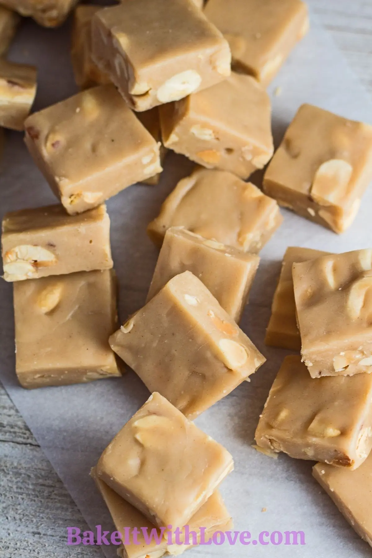 Creamy microwave peanut butter fudge sliced and scattered on parchment paper.