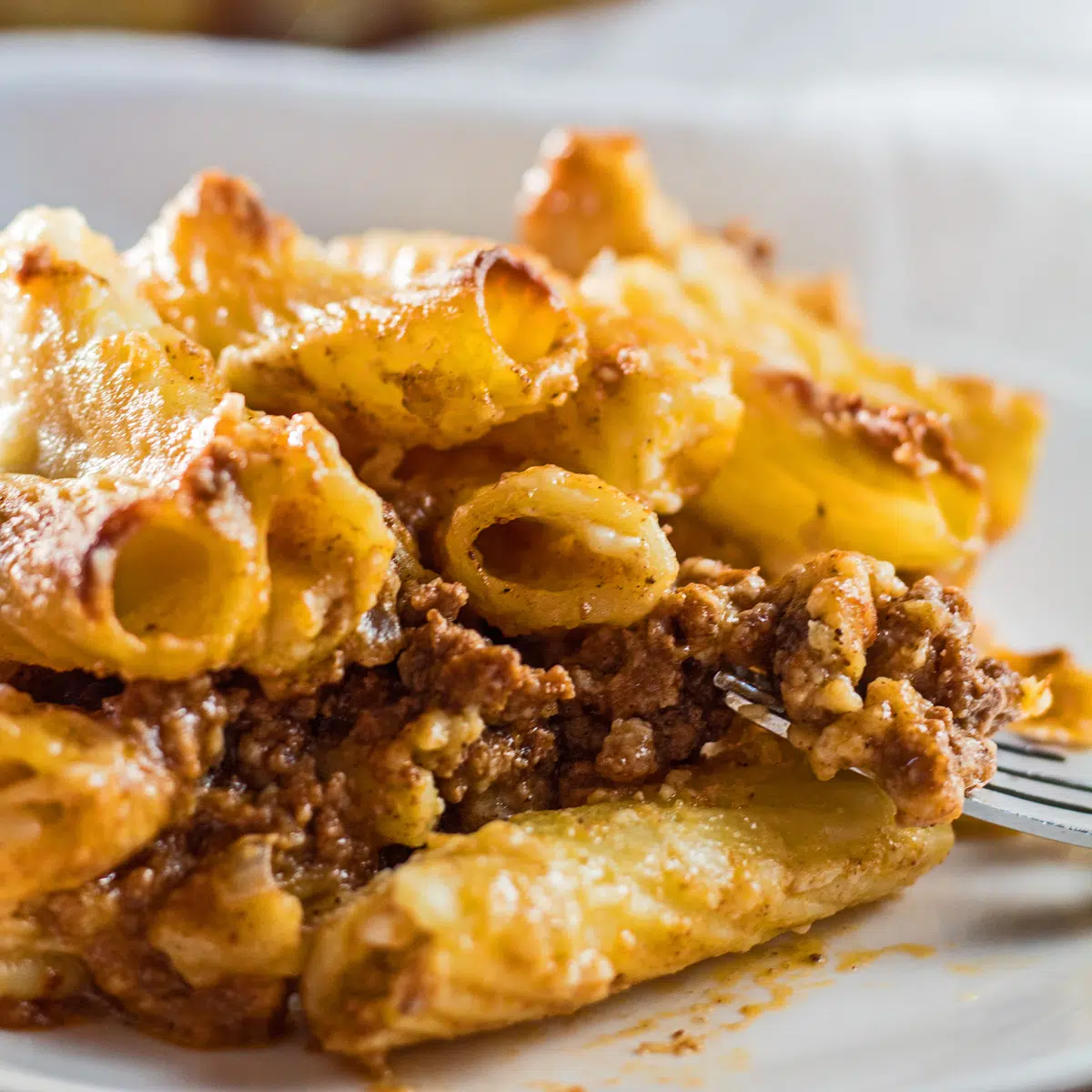 Layered bechamel pasta bake or macarona bechamel served on white dish.