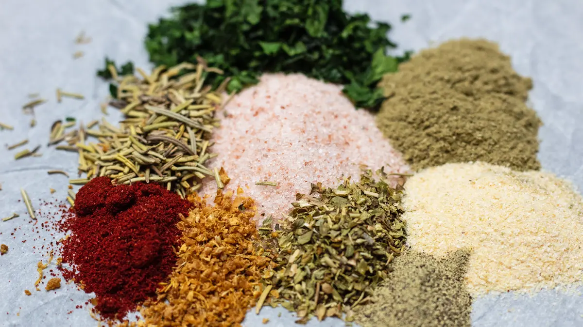 Lamb rub spices in small piles on a white background.