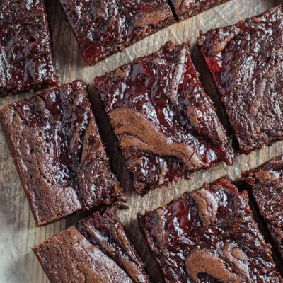 Strawberry swirl brownies cut and laid on parchment paper.
