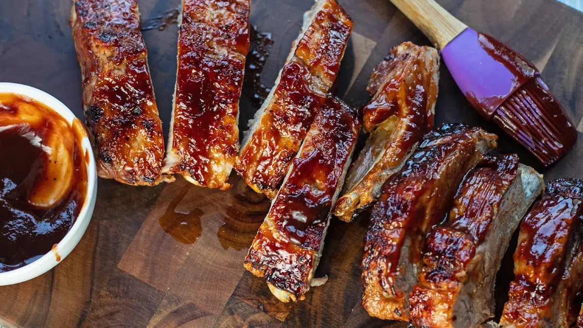 Sliced air fryer pork ribs on dark wooden cutting board.