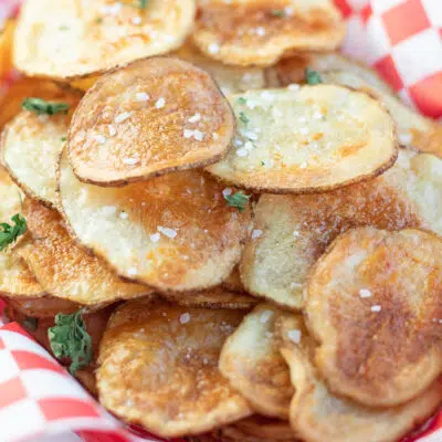Piled air fryer potato chips in a picnic basket.