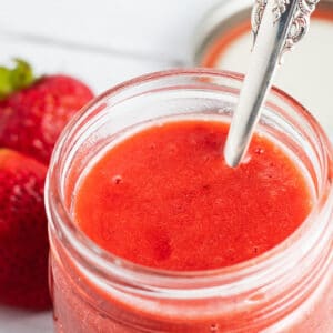 Strawberry coulis pureed and ready to serve from storage jar.