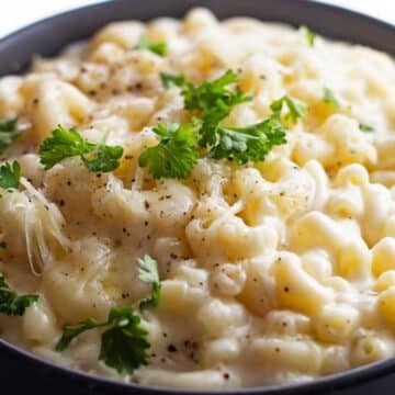 Creamy stovetop white cheddar mac and cheese served in black bowl.