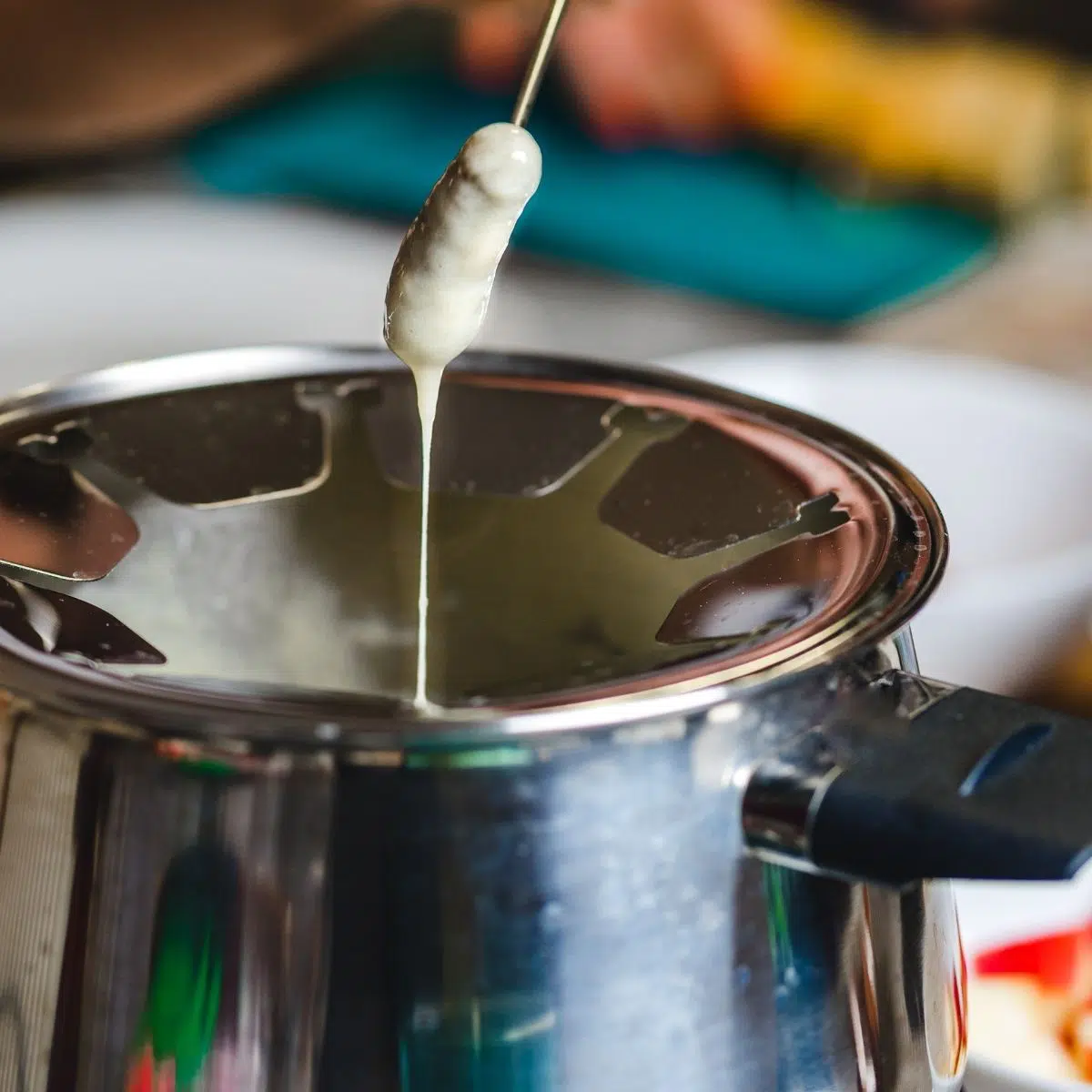 Cheese fondue pot being dipped into.
