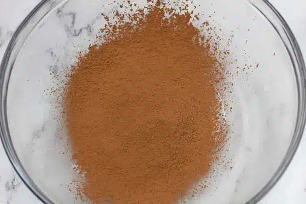 Process photo 1 of the sifted cocoa powder in large mixing bowl.