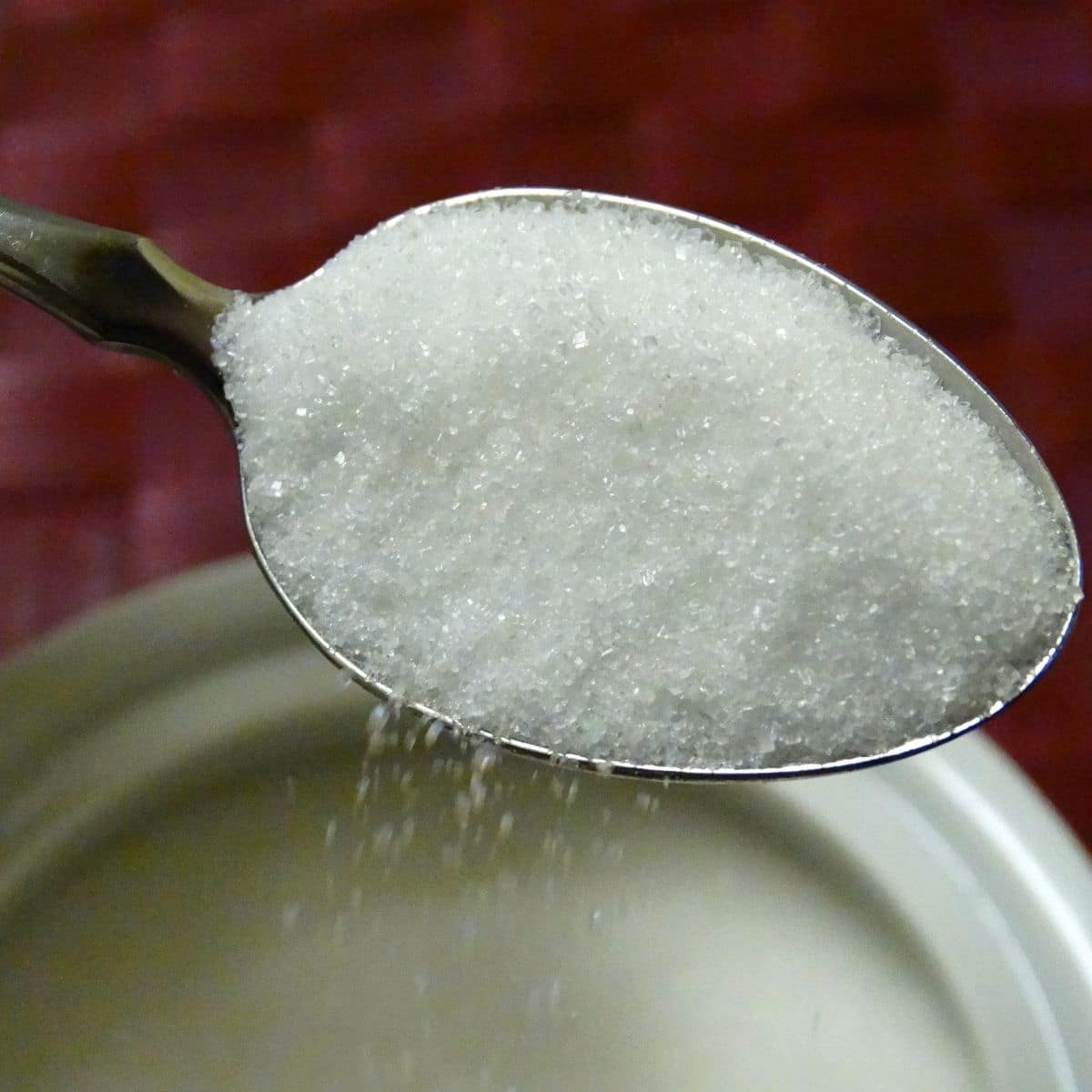 Sugar being spooned from container.