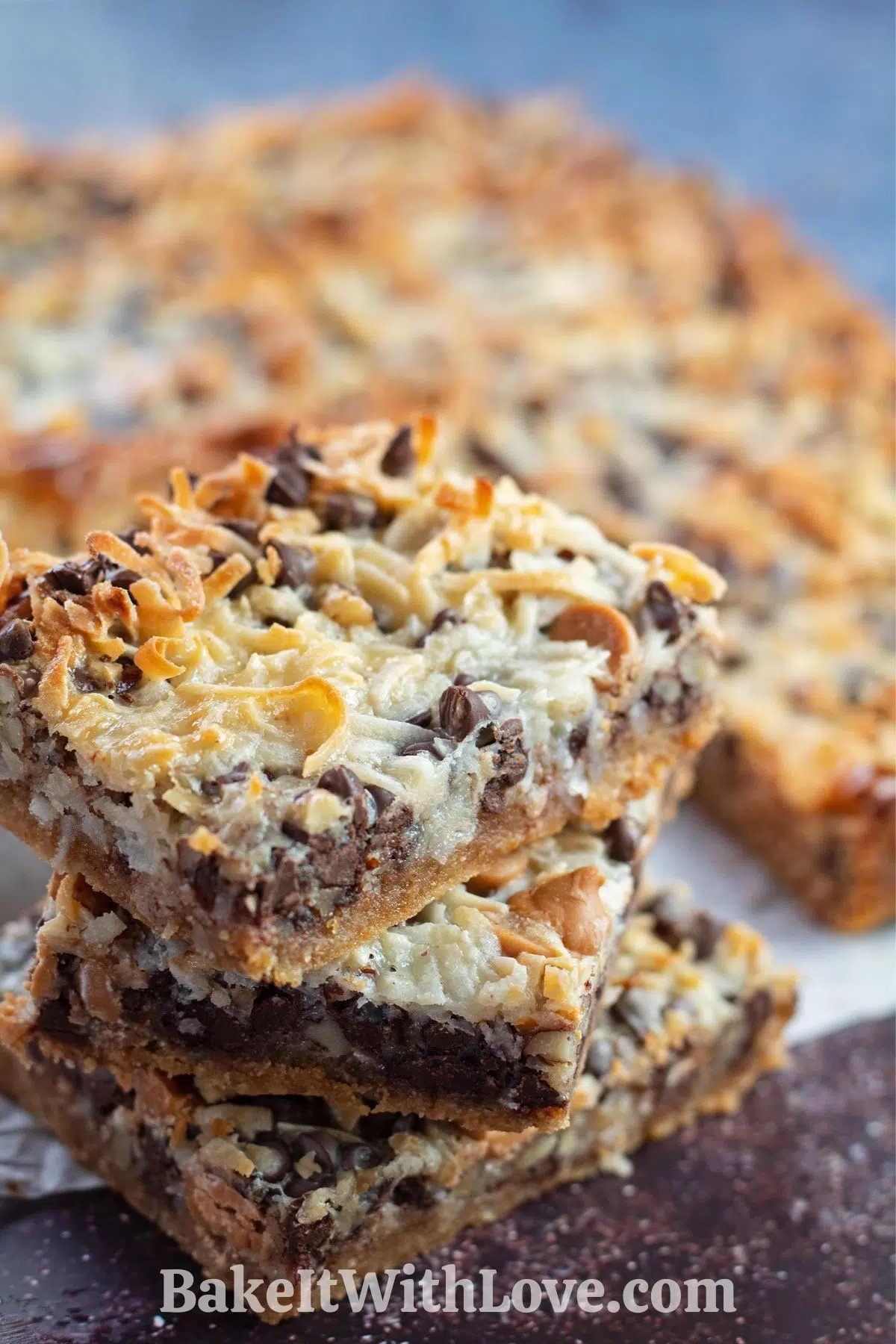 Stacked Hello Dolly Bars on parchment paper.