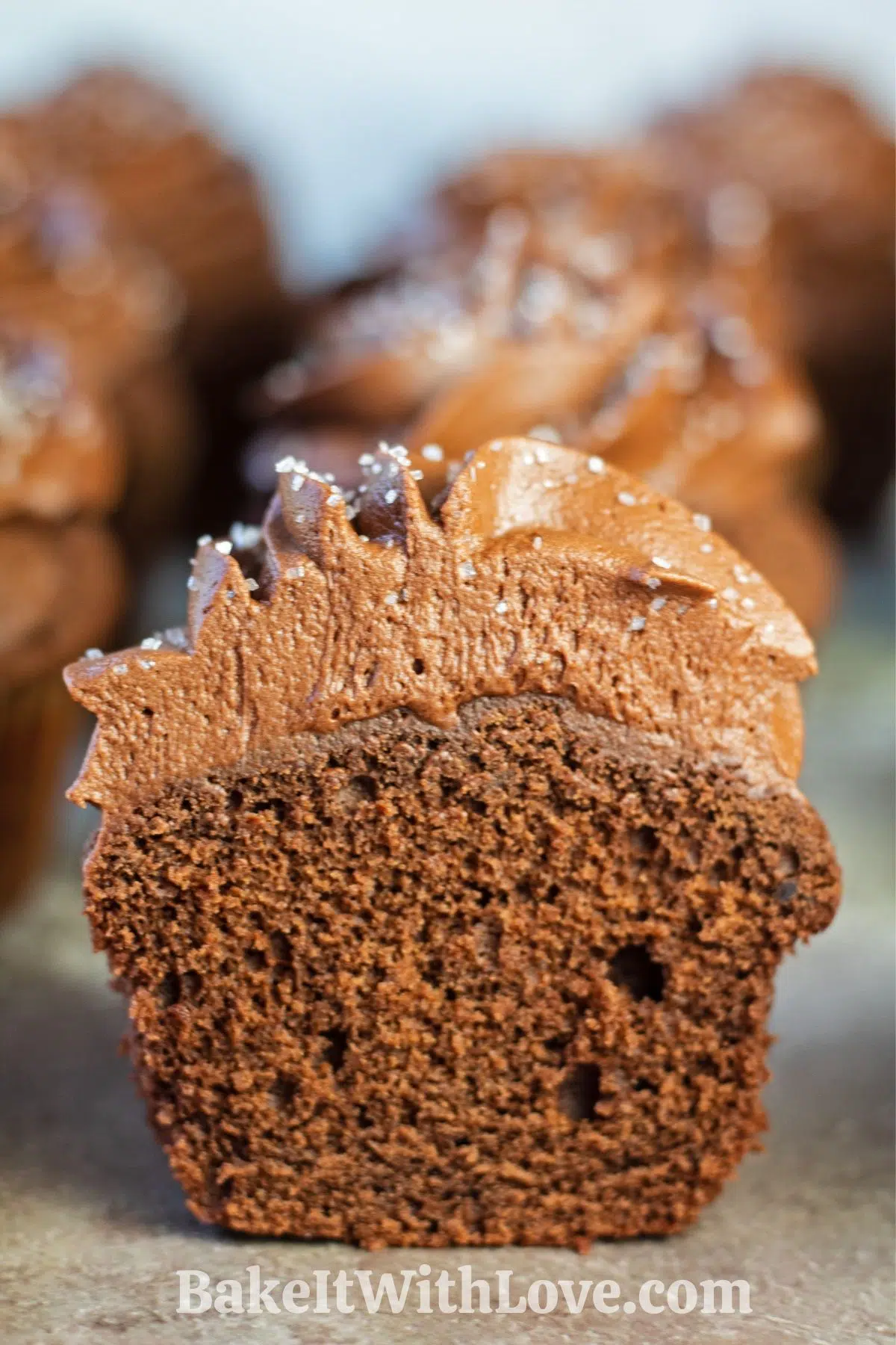 Tall closeup image of the baked Mary Berry chocolate cupcakes sliced in half showing cake texture.