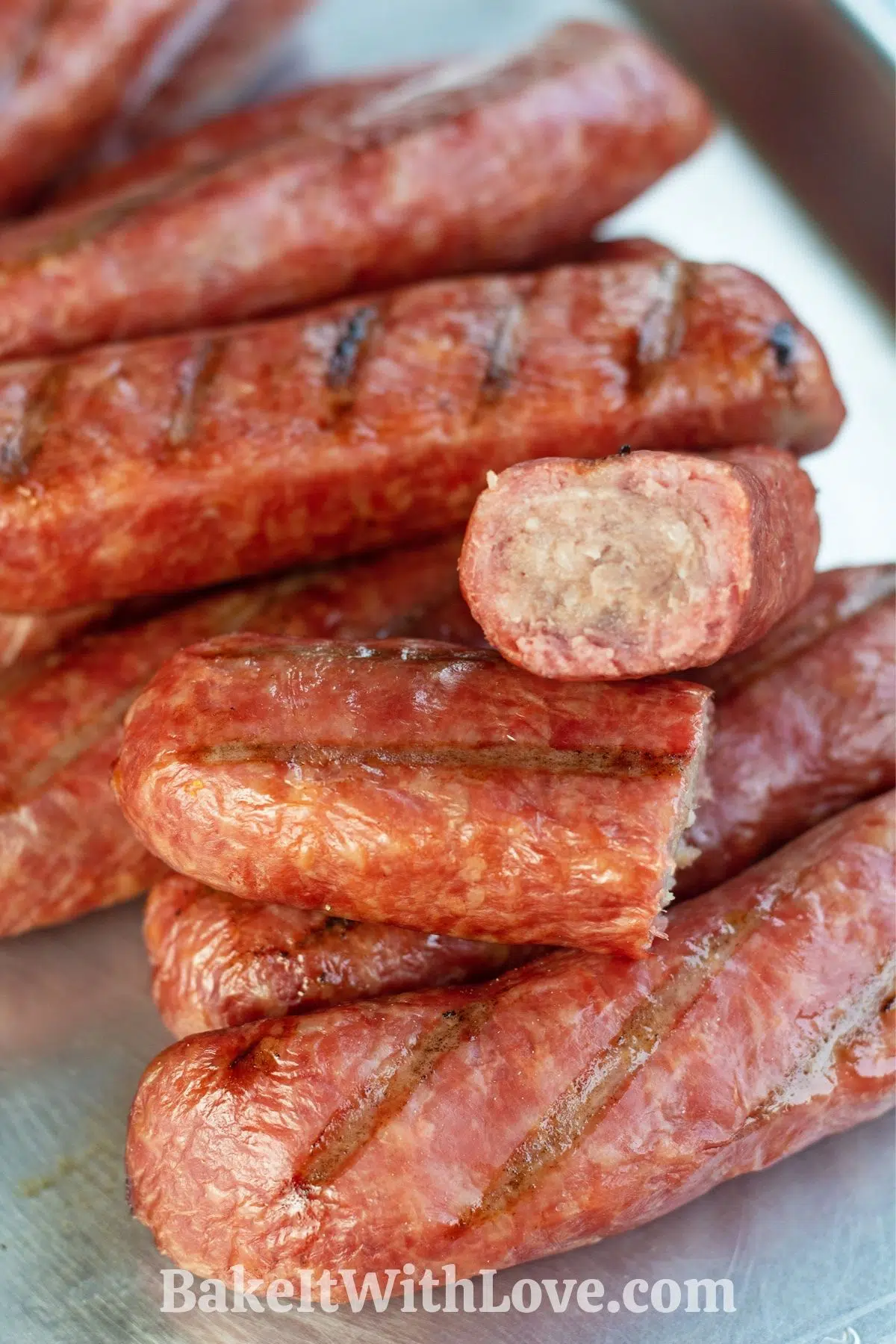 Smoked brats served on metal tray.