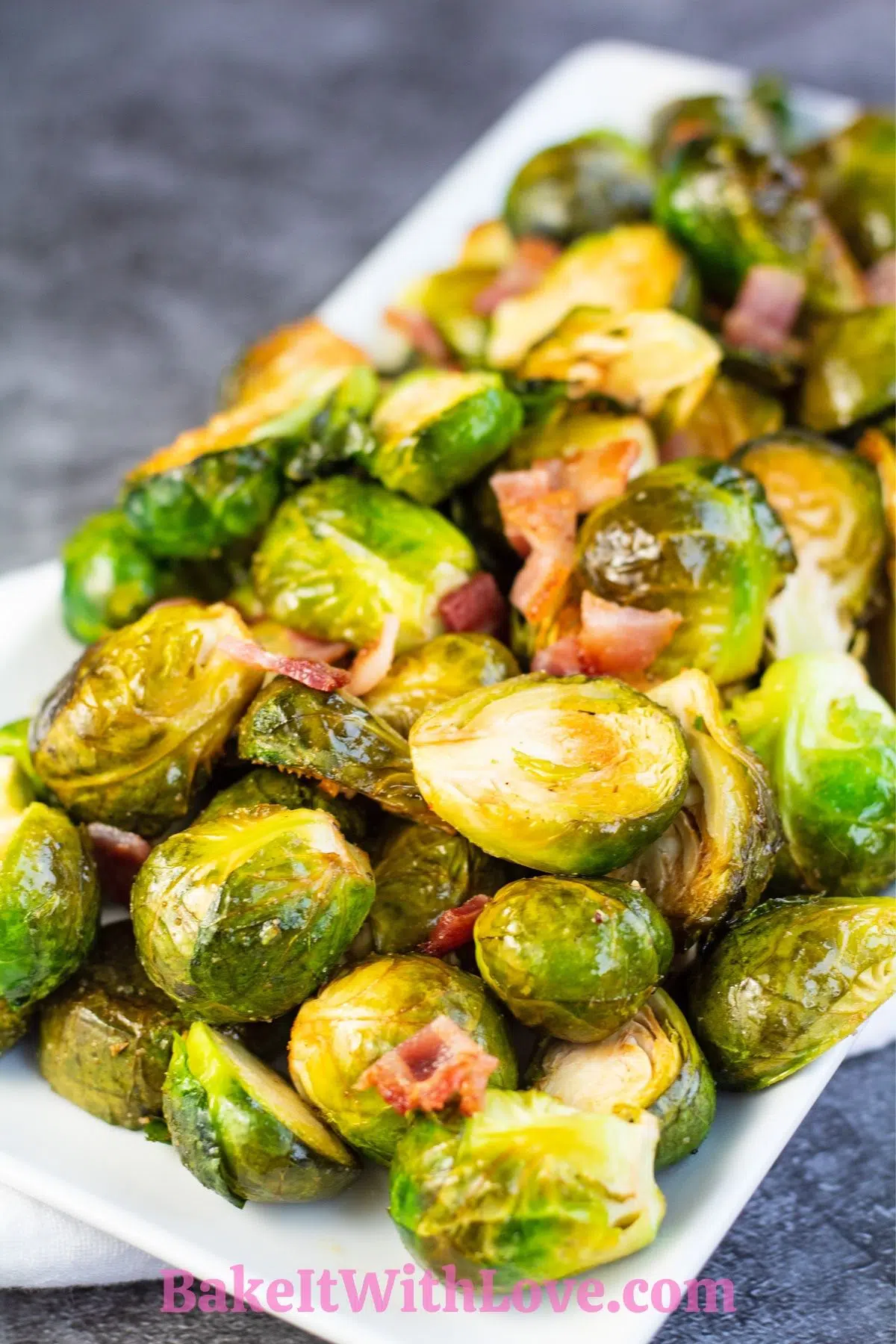Hearty smoked brussel sprouts tossed in batter with bacon and served on white platter.