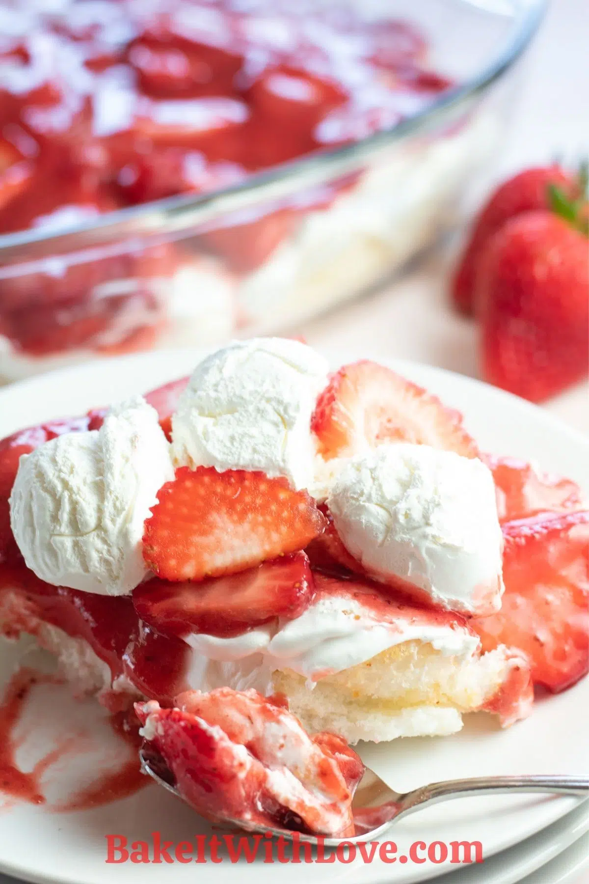 Tall image of the strawberry angel food lush dessert served on white plate.