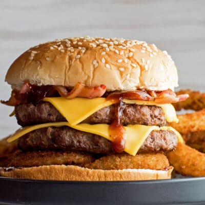 Zapadni cheeseburger sa slaninom sa strane kolutića luka.