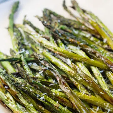 Air fryer asparagus roasted to perfection and served in tray.