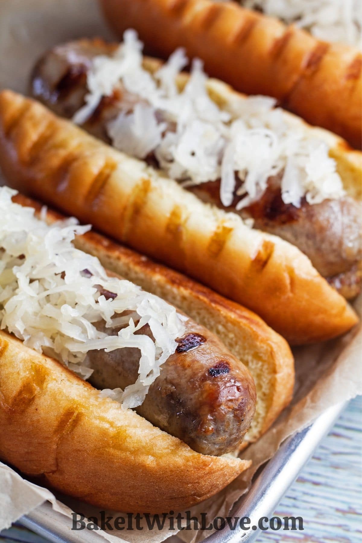 Grilled brats served on tray with German mustard and sauerkraut.