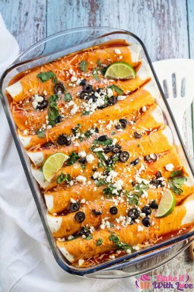 Tall overhead image of the baked cheese enchiladas in glass baking dish.