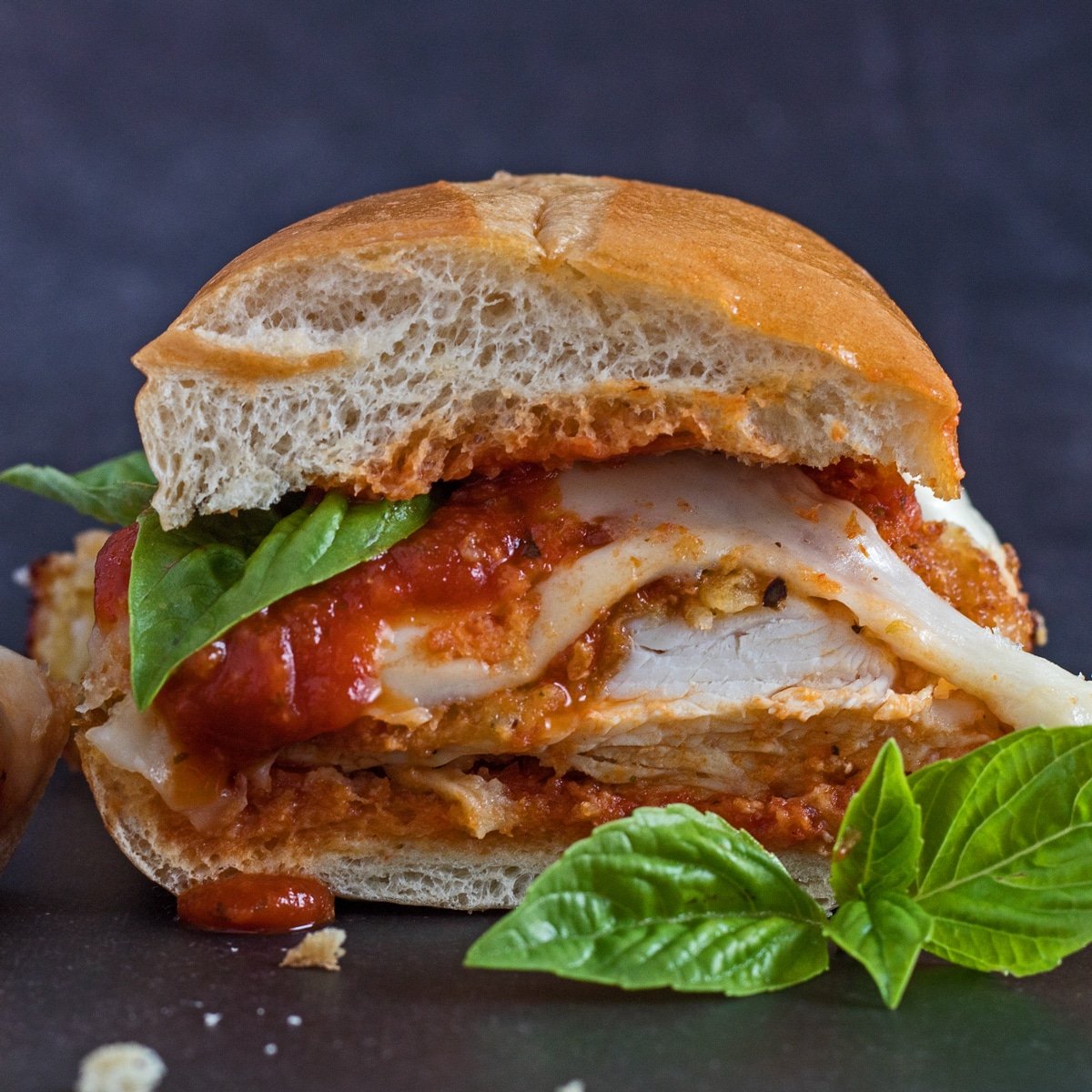 Sandwich au poulet parmesan avec le côté coupé vers la caméra.